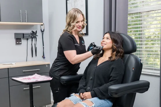 Jennifer Fleming FNP administering dermal filler injection to female patient in Beauty Aesthetics treatment room Lutz FL