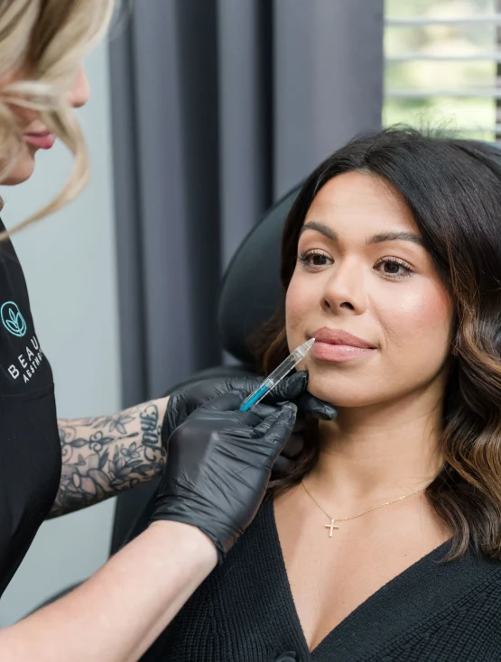 Jennifer Fleming FNP injecting lip filler into female patient at Beauty Aesthetics med spa in Lutz FL